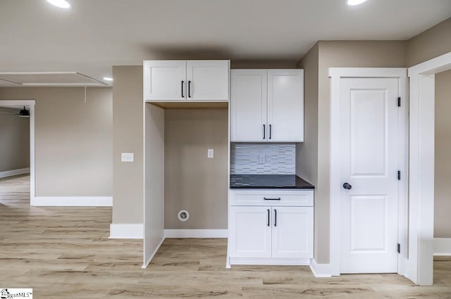 kitchen featuring light wood-type flooring, white cabinetry, and backsplash