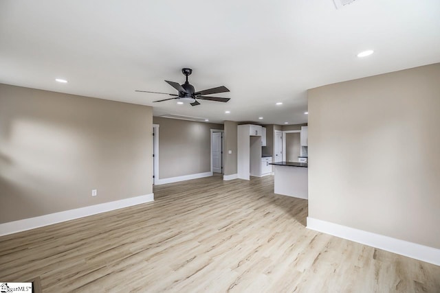 unfurnished living room featuring ceiling fan and light hardwood / wood-style flooring