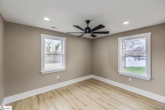 empty room with light hardwood / wood-style floors, ceiling fan, and a healthy amount of sunlight