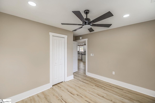 unfurnished bedroom featuring a closet, light hardwood / wood-style floors, and ceiling fan