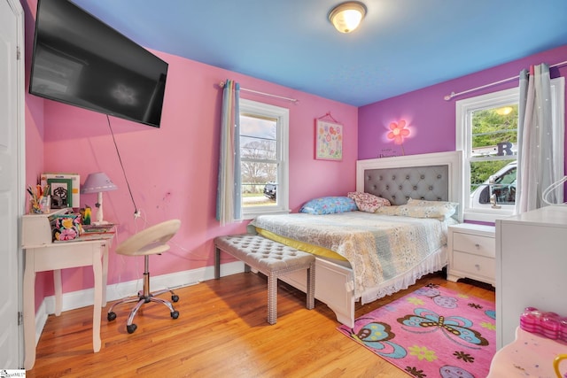 bedroom with multiple windows and wood-type flooring