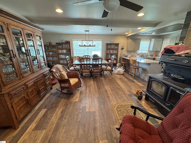 living room with beamed ceiling, dark hardwood / wood-style flooring, a wealth of natural light, and sink