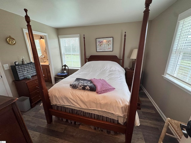 bedroom featuring dark hardwood / wood-style flooring, connected bathroom, and multiple windows