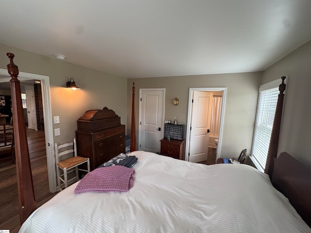 bedroom featuring ensuite bath and dark wood-type flooring