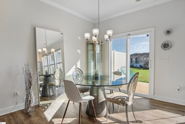 dining area with hardwood / wood-style flooring, ornamental molding, and an inviting chandelier