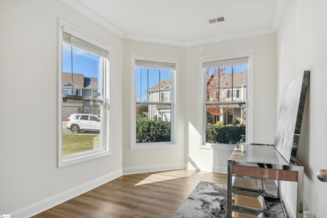 entryway with wood-type flooring and crown molding