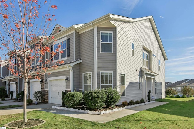 view of property featuring a garage and a front lawn