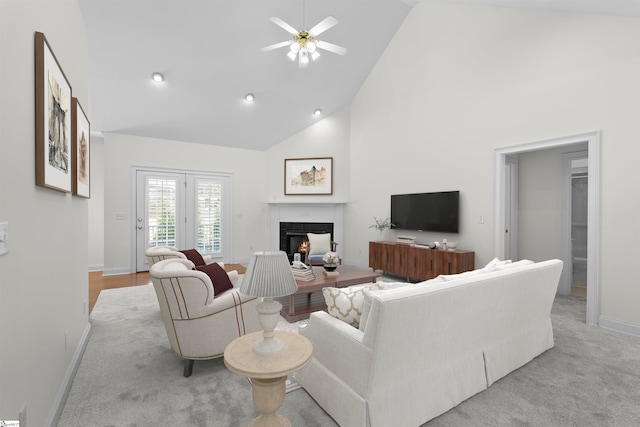 carpeted living room featuring ceiling fan and high vaulted ceiling