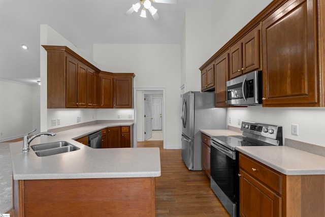 kitchen featuring sink, dark hardwood / wood-style floors, ceiling fan, kitchen peninsula, and stainless steel appliances