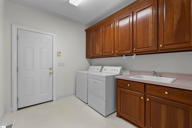 washroom featuring cabinets, independent washer and dryer, and sink