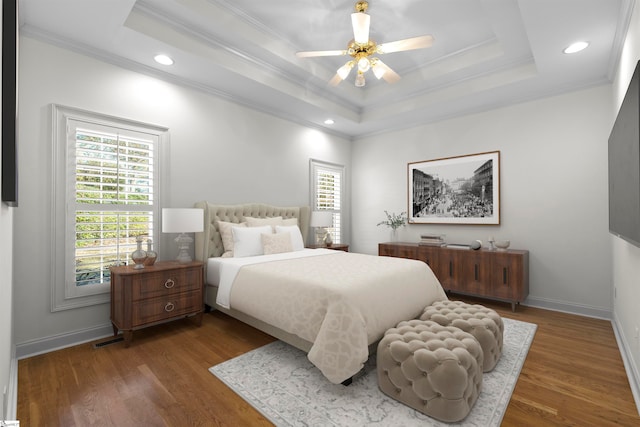 bedroom with a raised ceiling, ceiling fan, dark hardwood / wood-style flooring, and crown molding