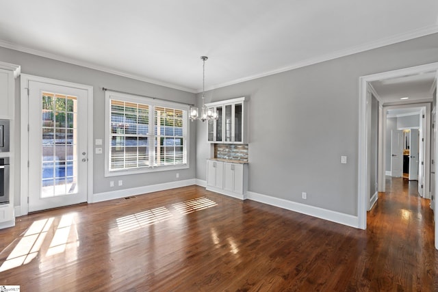 unfurnished dining area with crown molding, dark hardwood / wood-style floors, and a notable chandelier