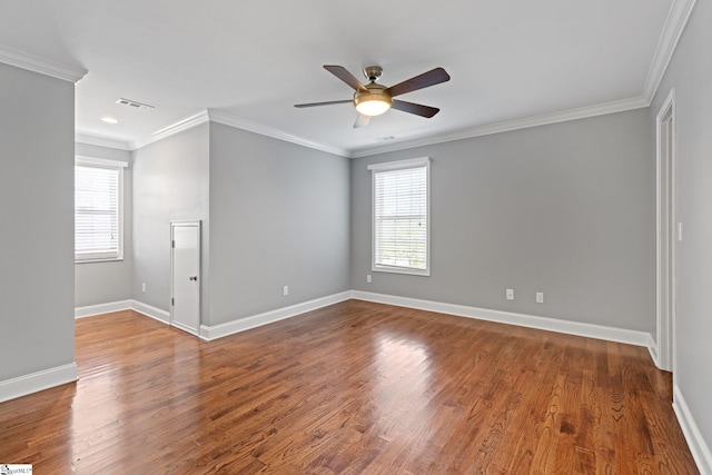 empty room featuring a wealth of natural light, ceiling fan, ornamental molding, and hardwood / wood-style flooring