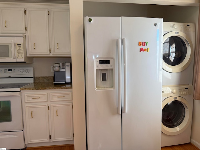 kitchen featuring white appliances, dark stone counters, stacked washer and clothes dryer, light hardwood / wood-style flooring, and white cabinetry