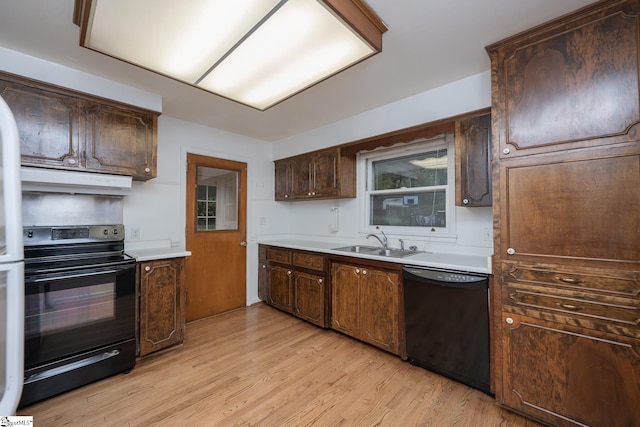 kitchen with dark brown cabinetry, sink, black appliances, light wood-type flooring, and exhaust hood