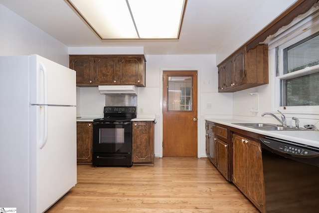 kitchen featuring dark brown cabinets, sink, light hardwood / wood-style floors, and black appliances