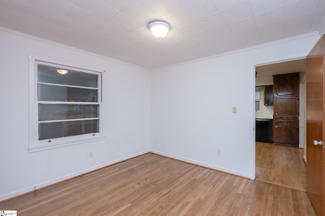 empty room featuring ornamental molding and light hardwood / wood-style flooring