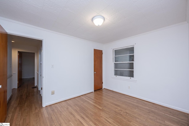 empty room with hardwood / wood-style flooring and ornamental molding