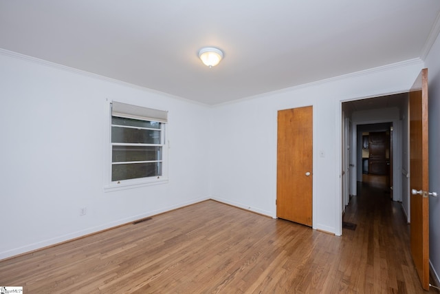 spare room with hardwood / wood-style floors and ornamental molding