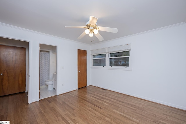 unfurnished bedroom with hardwood / wood-style flooring, ornamental molding, ceiling fan, and ensuite bath