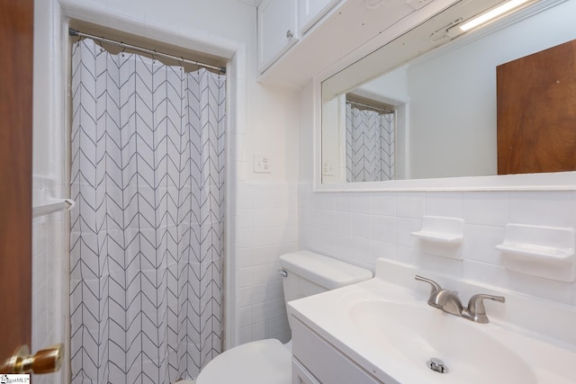 bathroom featuring vanity, toilet, curtained shower, and tile walls