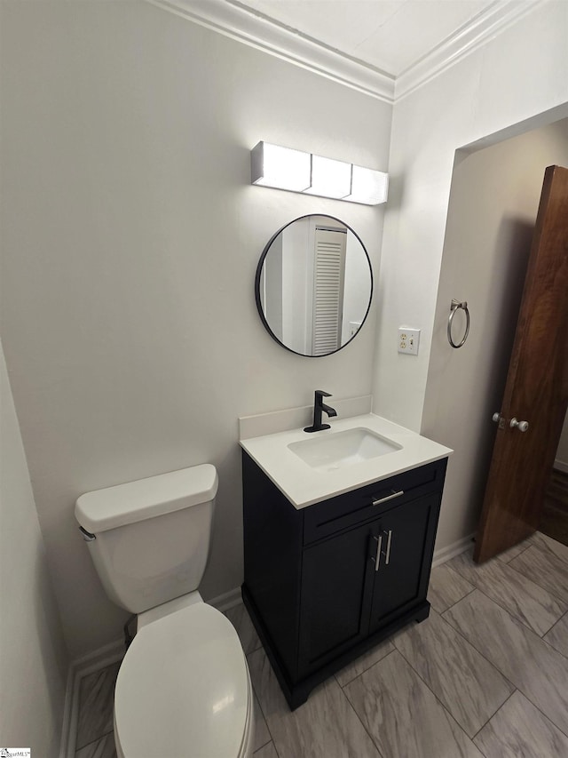 bathroom with vanity, crown molding, and toilet