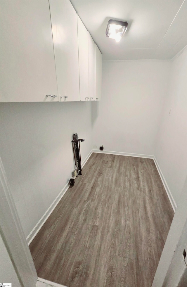 laundry room with hardwood / wood-style floors and cabinets