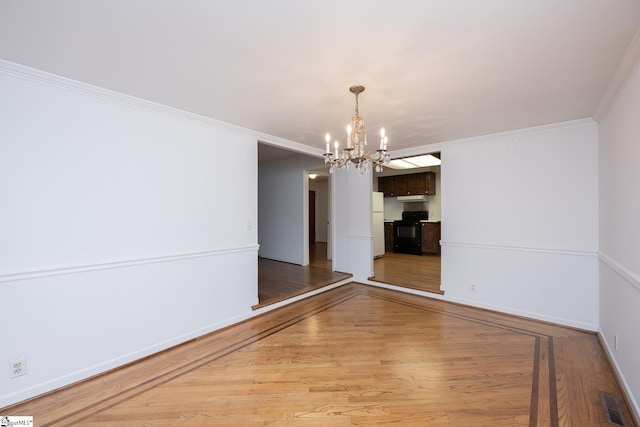 unfurnished dining area featuring an inviting chandelier, wood-type flooring, and ornamental molding