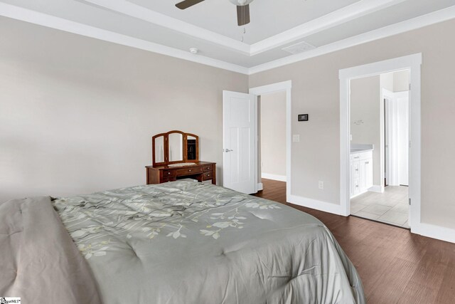 bedroom featuring ensuite bath, ceiling fan, and dark wood-type flooring