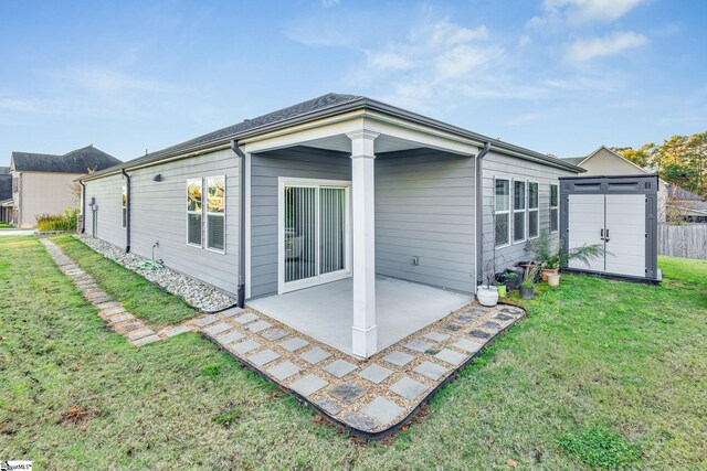 rear view of house featuring a lawn, a patio area, and a shed