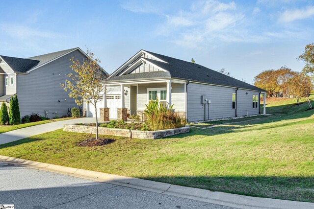 view of front facade with a front lawn, covered porch, and a garage