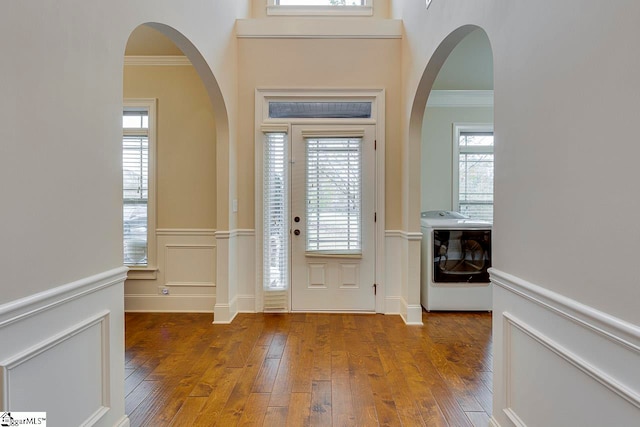 foyer entrance with ornamental molding, washer / clothes dryer, and dark wood-type flooring