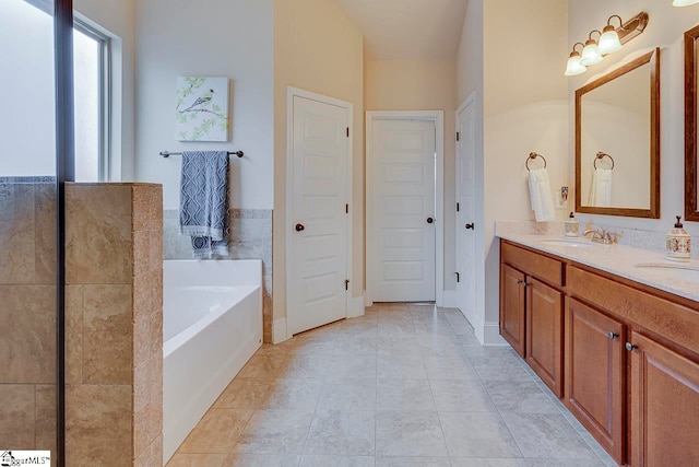 bathroom featuring tile patterned flooring, vanity, and a tub to relax in