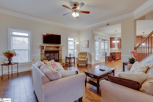 living room with hardwood / wood-style flooring, plenty of natural light, and ornamental molding