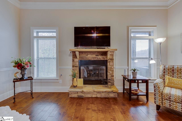 living area with wood-type flooring, plenty of natural light, and ornamental molding