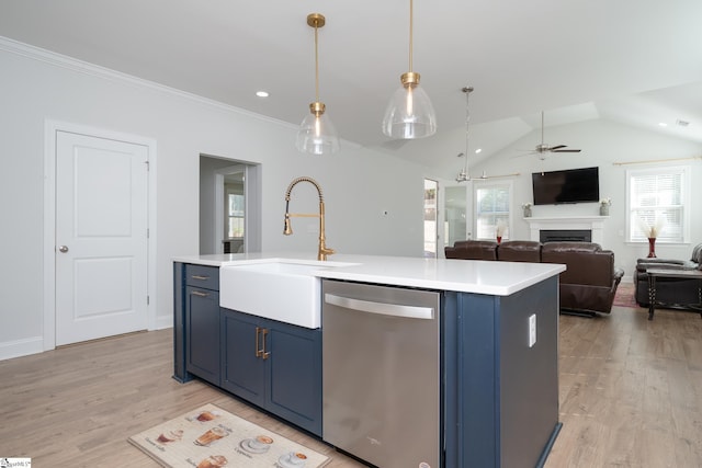 kitchen featuring stainless steel dishwasher, a healthy amount of sunlight, and an island with sink