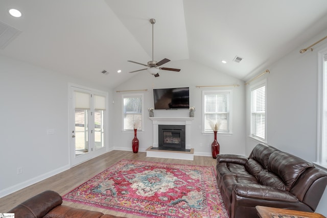 living room with ceiling fan, lofted ceiling, and light hardwood / wood-style flooring