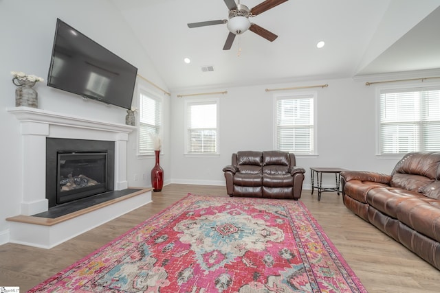 living room featuring ceiling fan, light wood-type flooring, and lofted ceiling