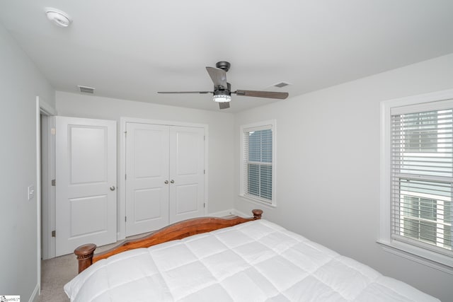 bedroom featuring ceiling fan, light colored carpet, and a closet