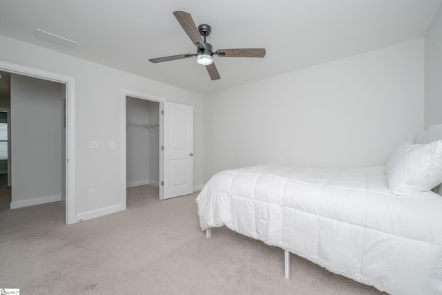 carpeted bedroom featuring ceiling fan, a spacious closet, and a closet