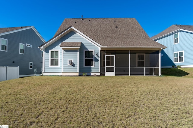 back of property with a yard and a sunroom