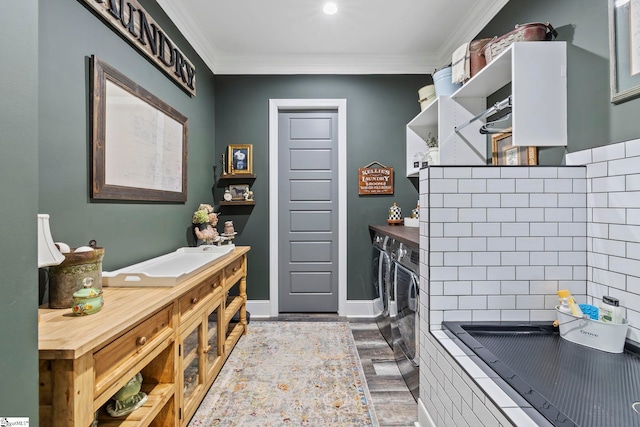 clothes washing area featuring washer and clothes dryer, wood-type flooring, and ornamental molding