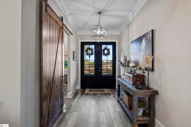 foyer entrance with french doors, a barn door, dark hardwood / wood-style floors, and ornamental molding