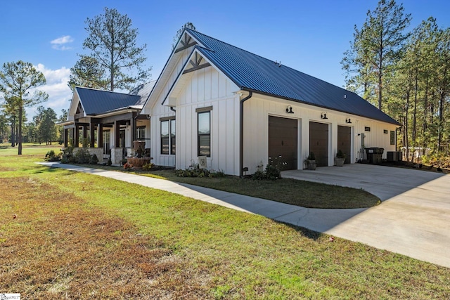 view of front of home with covered porch, a garage, and a front lawn