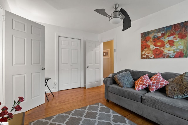 living room featuring wood-type flooring and ceiling fan