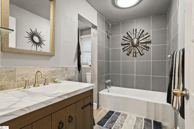 bathroom with tasteful backsplash, tile walls, vanity, and tiled shower / bath combo