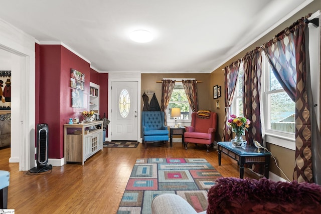 sitting room featuring wood-type flooring, ornamental molding, and a wealth of natural light