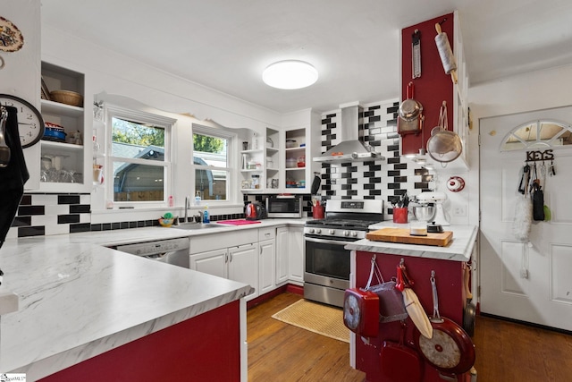 kitchen with wall chimney exhaust hood, stainless steel appliances, dark wood-type flooring, sink, and white cabinets