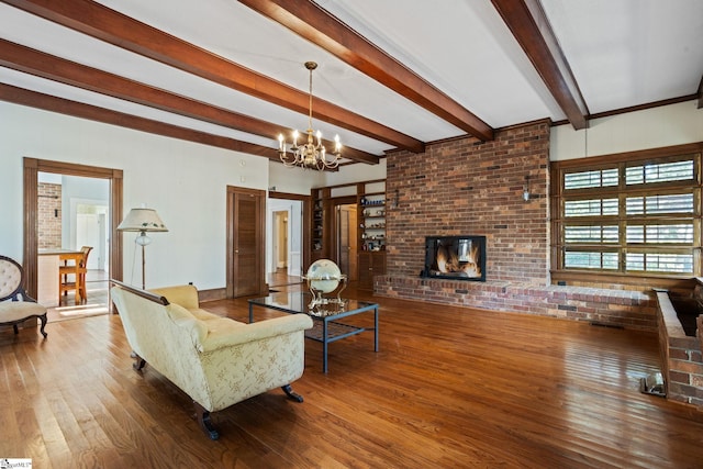 living room with a fireplace, hardwood / wood-style flooring, an inviting chandelier, and beamed ceiling