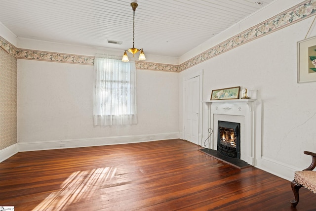 unfurnished living room featuring a chandelier, ornamental molding, and dark wood-type flooring